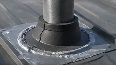 Inspecting a pipe boot and sealant detail on a metal roof