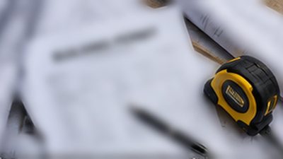 Building permit paperwork and roofing plans on a desk